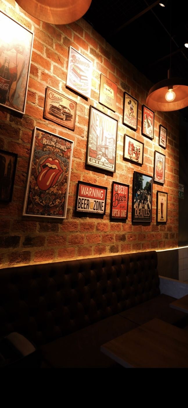 Pared de ladrillo con afiches de rock en RUDO
